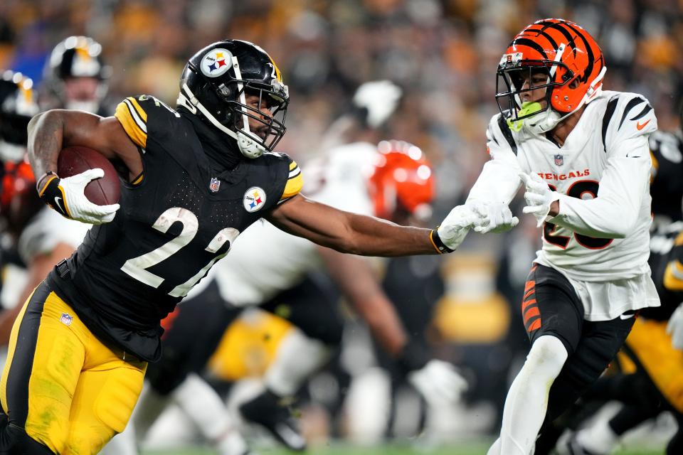 Pittsburgh Steelers running back Najee Harris (22) carries the ball as Cincinnati Bengals cornerback DJ Turner II (20) defends in the third quarter during a Week 16 NFL football game between the Cincinnati Bengals and the Pittsburgh Steelersl, Saturday, Dec. 23, 2023, at Acrisure Stadium in Pittsburgh, Pa.