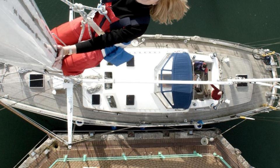 A young female sailor up a mast.