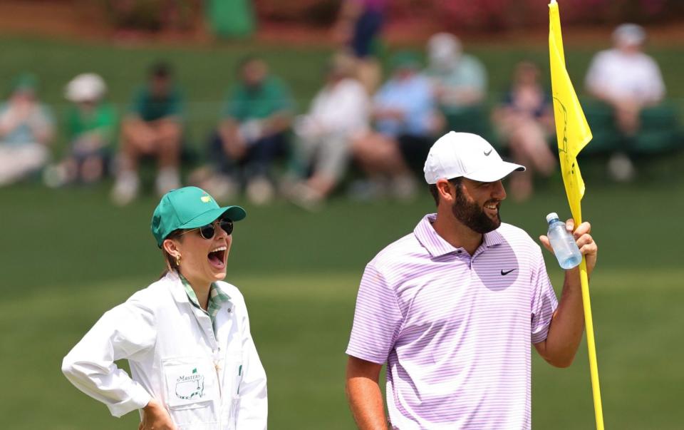 Scottie Scheffler de EE.UU. y su esposa, Meredith Scudder, reaccionan en el sexto green durante el concurso de par 3