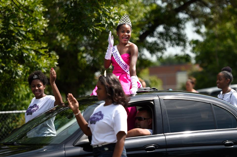 Miss Juneteenth waves out of a car during a parade.