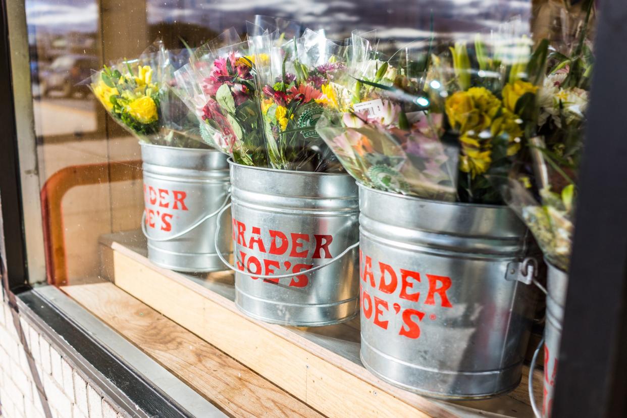 Fairfax: Buckets of flowers with Trader Joe's signs viewed from outside of store