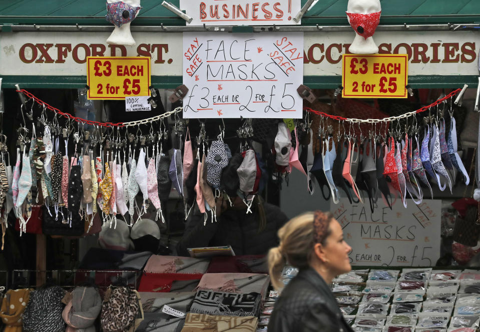 FILE - In this Tuesday, Oct. 13, 2020 file photo a shop sells face masks on Oxford Street in London. Unemployment across the U.K. rose sharply higher in August which is a clear indication that the jobless rate is set to spike higher when a government salary-support scheme ends this month and new restrictions are imposed on local areas to suppress a resurgence of the coronavirus.(AP Photo/Frank Augstein, File)