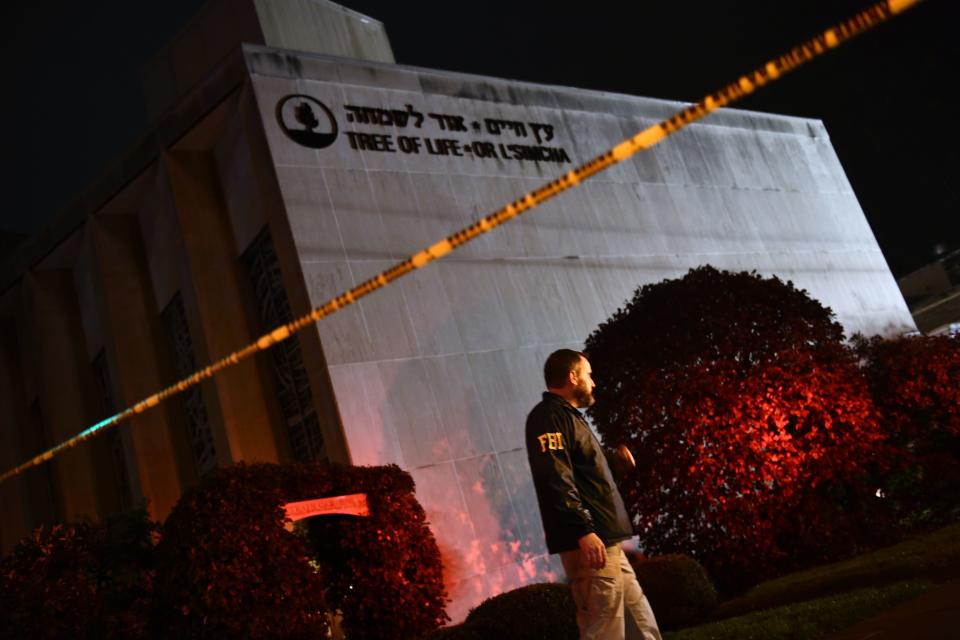 An FBI agent stands behind a police cordon outside the Tree of Life Synagogue after a shooting there left 11 people dead in the Squirrel Hill neighborhood of Pittsburgh on October 27, 2018. The shooting was the deadliest anti-Semitic attack in recent American history. (Brendan Smialowski / AFP via Getty Images)