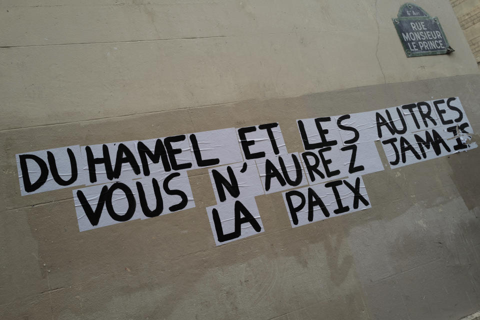 Signs on the wall reads "Duhamel, and the others, you will never be in peace" referring to prominent French political expert Olivier Duhamel, in Paris, Tuesday, Jan. 19, 2021. The French government pledged on Thursday to toughen laws on the rape of children, as a massive online movement has seen hundreds of victims share accounts about sexual abuses within their families under the hashtag #MeTooInceste. (AP Photo/Francois Mori)