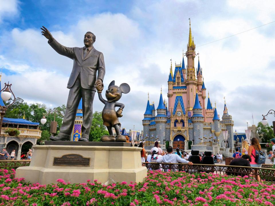 Statue of Walt Disney and Mickey Mouse at Cinderella Castle in Magic Kingdom at Walt Disney World in Florida.