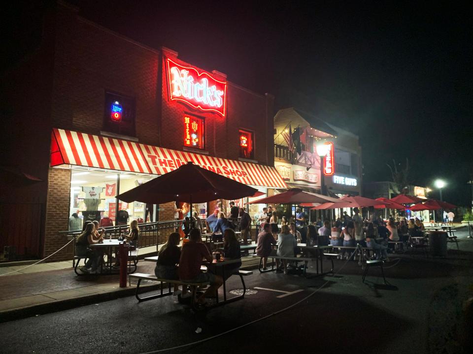 People congregate Thursday outside Nick's bar in Bloomington, near the Indiana University campus.