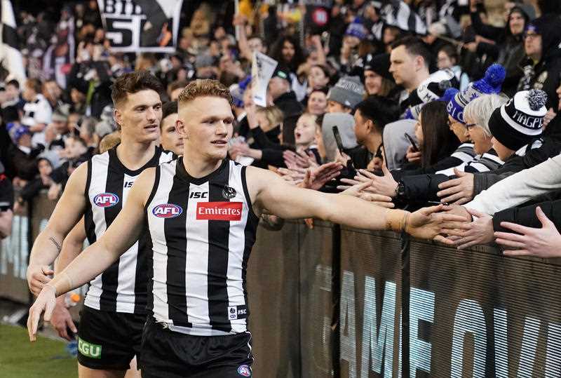 Adam Treloar of the Magpies celebrates with supporters in the crowd after winning during the Round 23 AFL match between the Collingwood Magpies and the Essendon Bombers at the MCG in Melbourne.
