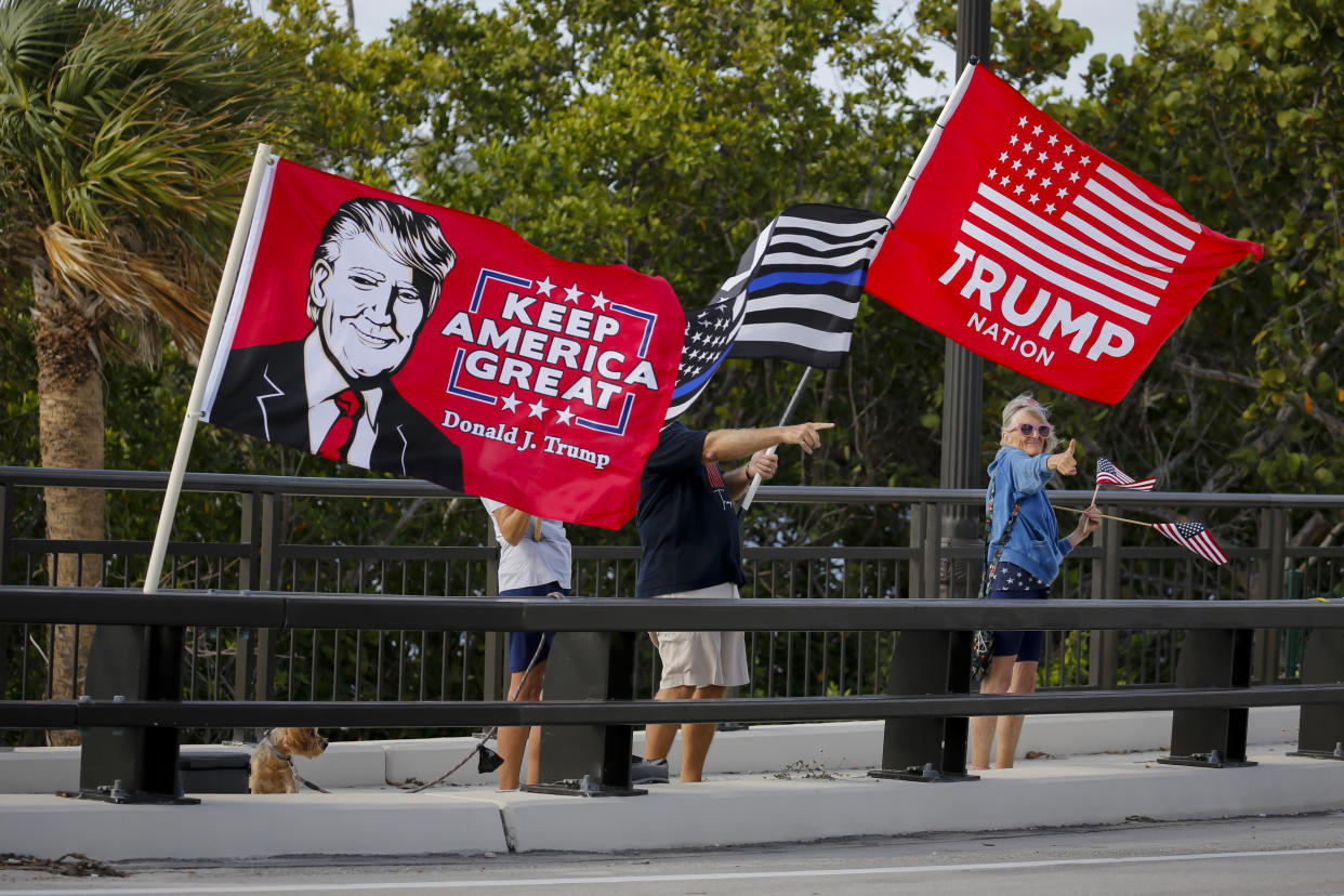 Trump supporters holding flags saying: Trump Nation and Keep America Great.