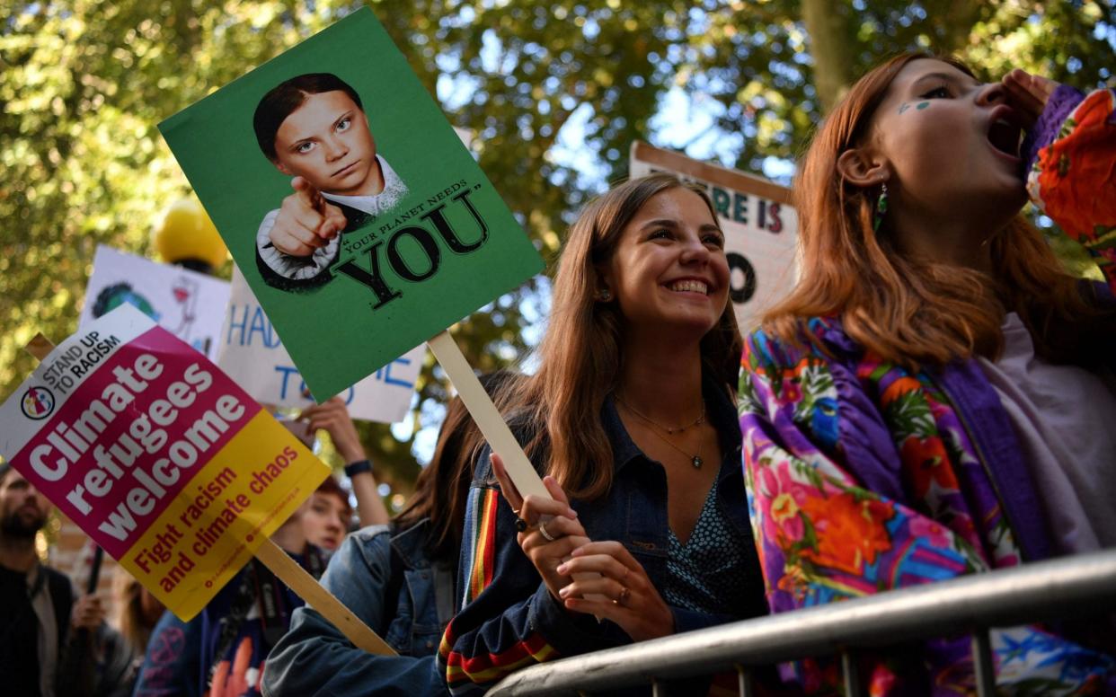 Environmental activists rally at the protest in London - AFP