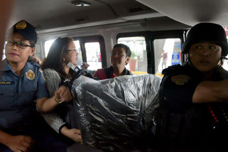 Maria Ressa, head of Philippine news website Rappler, is seen in a vehicle with police after arrival at Manila airport on Friday March 29, 2019 in this handout photo. Leanne Jazul/Rappler/Handout via REUTERS