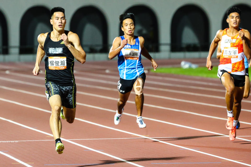 110年全國運動會男子組田徑200公尺準決賽19日晚間舉行，代表花蓮縣出賽的「台灣最速男」楊俊瀚（左）跑出20秒61的成績，以分組第一之姿晉級決賽。（中央社）