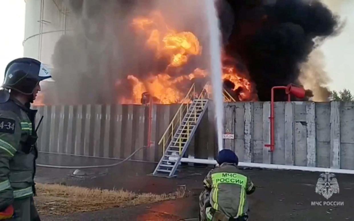 Russian firefighters try to extinguish a blaze at after an alleged drone attack