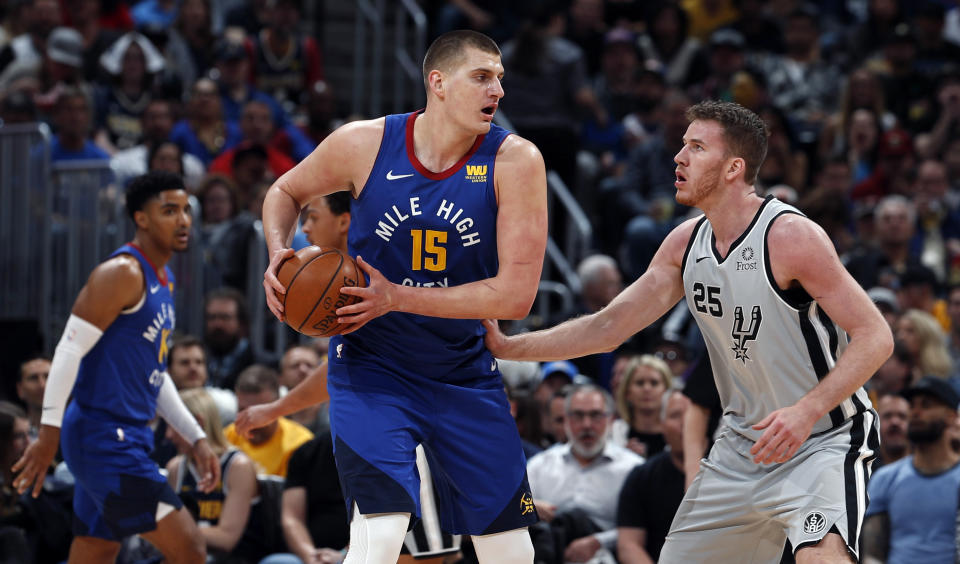 Denver Nuggets center Nikola Jokic (15) is pressured by San Antonio Spurs center Jakob Poeltl (25) in the first half of Game 5 of an NBA basketball first round playoff series, Tuesday, April 23, 2019, in Denver. (AP Photo/David Zalubowski)