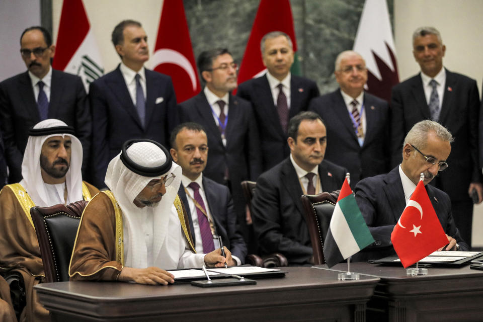 UAE's Energy Minister Suhail Mohamed al-Mazrouei, left, and Turkey's Transport Minister Abdulkadir Uraloglu, right, sign the "Development Road" framework agreement on security, economy, and development in Baghdad, Iraq, Monday April 22, 2024. (Ahmad Al-Rubaye/Pool via AP)