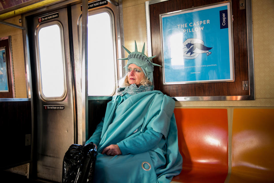 <p>Lindley Hanlon rides the A train leaving John F. Kennedy International Airport, where she dressed as the Statue of Liberty to welcome people entering through Terminal 4 in Queens, N.Y., Feb. 6, 2017. While at the airport, law enforcement approached Hanlon and made her put away a sign that read “Liberty and Justice for All.” Hanlon made her costume from Bed Bath and Beyond curtains and purchased the crown from a Halloween store in the East Village. “I think it’s more important than ever,” she said about the Statue of Liberty. “Because I think our liberties are threatened.” (Photograph by Sam Hodgson/The New York Times) </p>