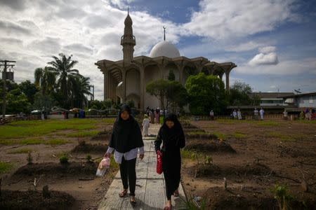 Muslims visit the graves of their loved ones on the first day of Eid al-Fitr, marking the end of the holy fasting month of Ramadan in Bangkok, Thailand, June 25, 2017. REUTERS/Athit Perawongmetha