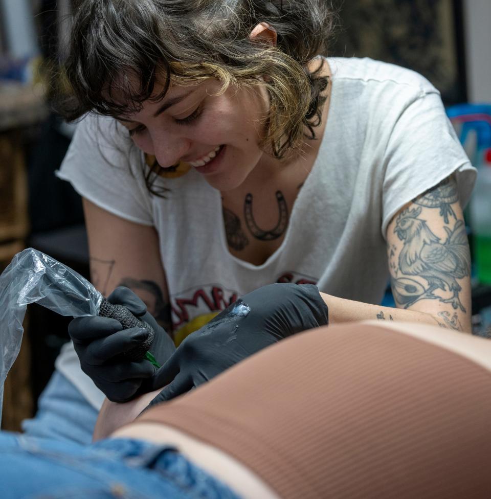Kay Robertson, a tattoo artist at Irish Ink Tattoo and Piercing, works on a design for Hannah McHenry, in the Perry Meridian neighborhood of Indianapolis, Tuesday, March 7, 2023.