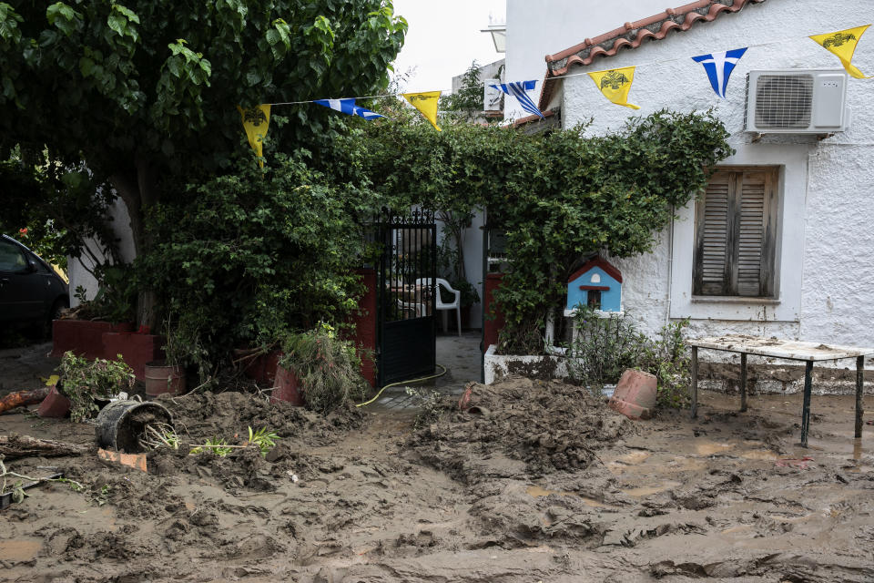 Mud covers the street in front of a house following a storm at the village of Politika, on Evia island, northeast of Athens, on Sunday, Aug. 9, 2020. Five people, including en elderly couple and an 8-month-old baby have been found dead, two more are missing and dozens have been trapped in their homes and cars as a storm hits the island of Evia in central Greece, authorities said Sunday. (AP Photo/Yorgos Karahalis)