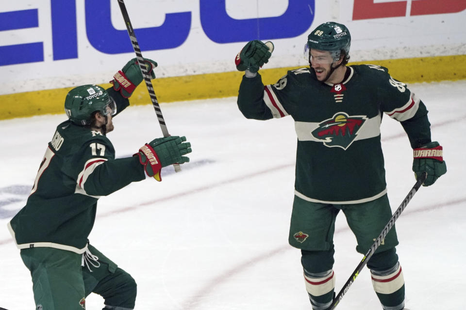 Minnesota Wild's Marcus Foligno, left, celebrates a goal by Frederick Gaudreau, right, against the St. Louis Blues during the first period of Game 2 of an NHL hockey Stanley Cup first-round playoff series Wednesday, May 4, 2022, in St. Paul, Minn. (AP Photo/Jim Mone)