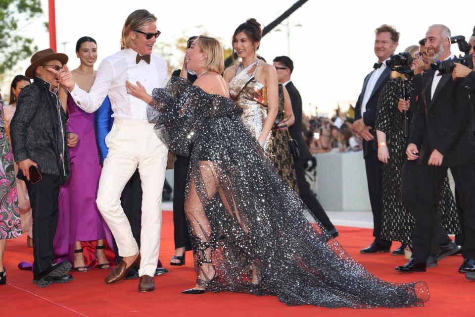Chris Pine, left, and Florence Pugh, center, laugh with each other upon arrival at the premiere of the film ‘Don’t Worry Darling’ during the 79th edition of the Venice Film Festival in Venice, Italy, (Vianney Le Caer/Invision/AP)
