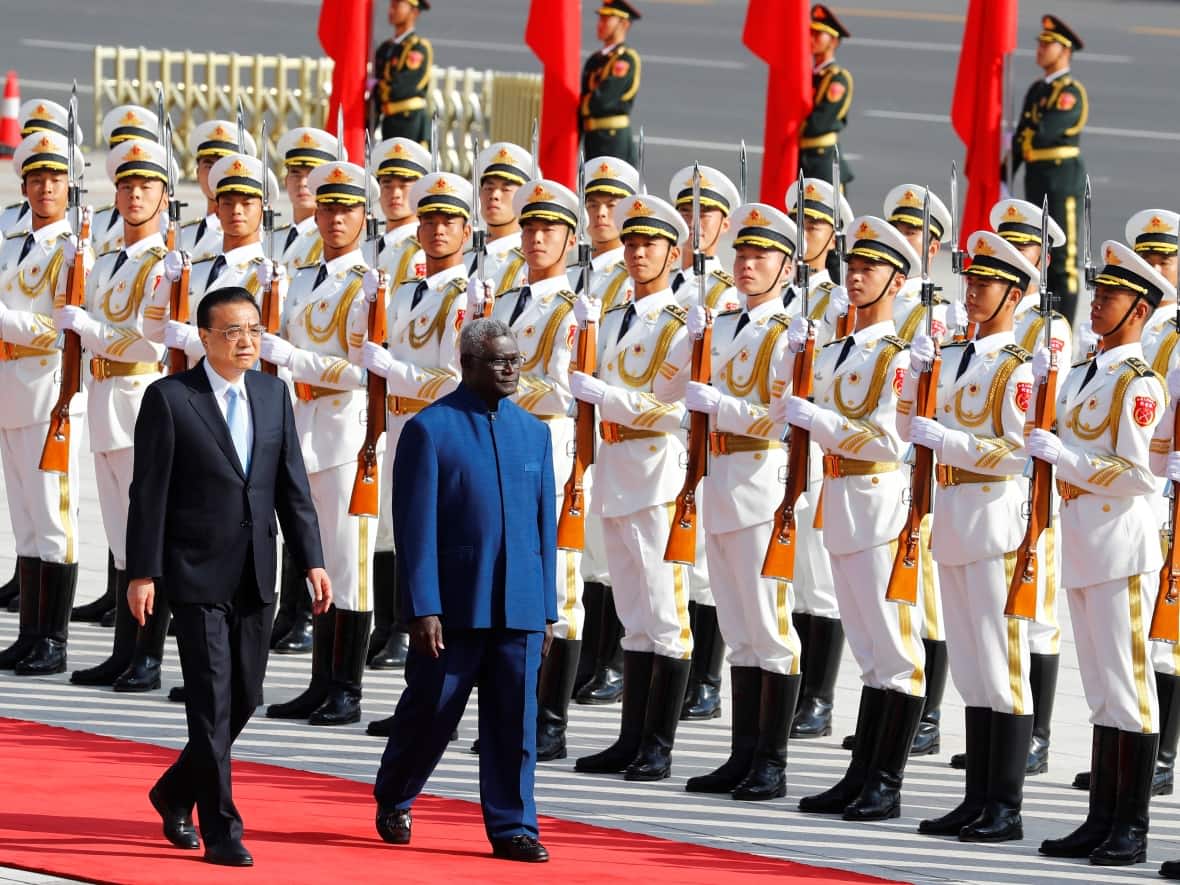 Solomon Islands Prime Minister Manasseh Sogavare is welcomed in China by then-premier Li Keqiang in 2019. Sogavare has since signed a security pact with China and delayed elections. (Thomas Peter/Reuters - image credit)