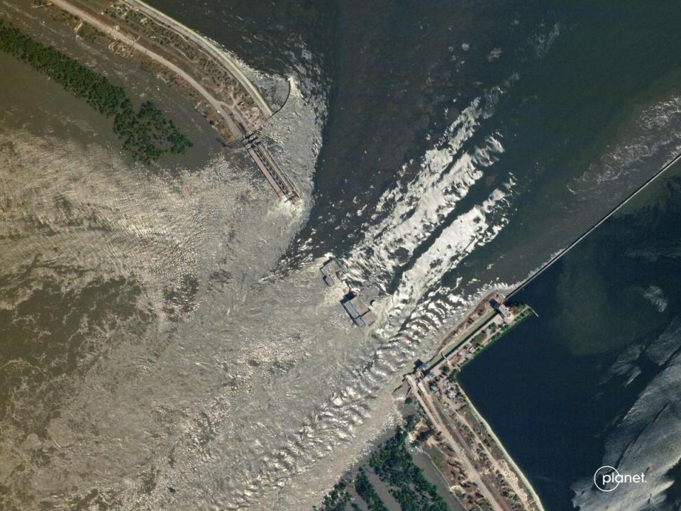 This handout SkySat image taken and released by Planet Labs PBC on June 6, 2023 shows water flowing through the damaged Kakhovka HPP dam in southern Ukraine (2023 Planet Labs PBC/AFP via Get)
