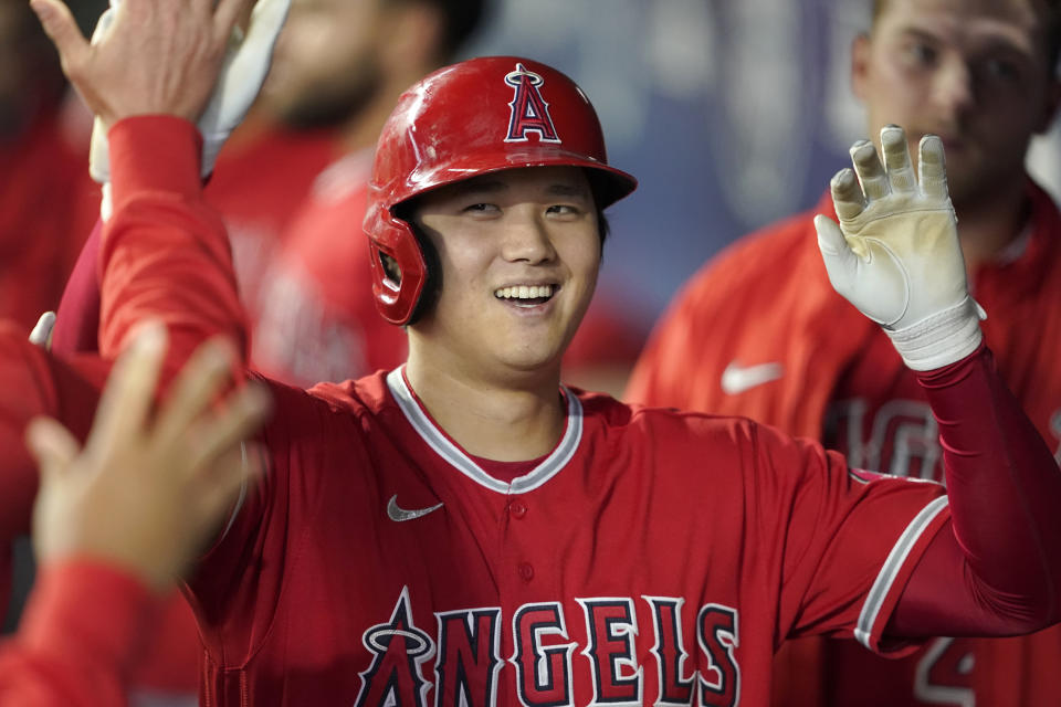 Los Angeles Angels' Shohei Ohtani is greeted in the dugout after he hit a solo home run during the first inning of a baseball game against the Seattle Mariners, Sunday, Oct. 3, 2021, in Seattle. (AP Photo/Ted S. Warren)