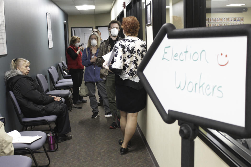 Observers speak with Clackamas County Elections Clerk Sherry Hall, right, as election workers review ballots on Thursday, May 19, 2022, Oregon City, Ore. Ballots with blurry barcodes that can't be read by vote-counting machines will delay election results by weeks in a key U.S. House race in Oregon's primary. (AP Photo/Gillian Flaccus)