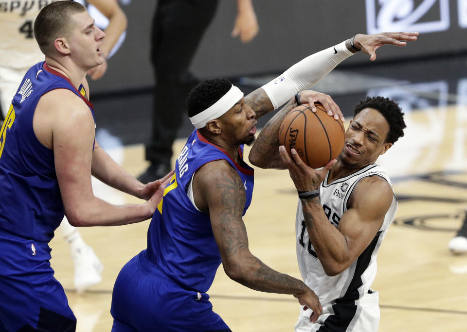 San Antonio Spurs guard DeMar DeRozan (10) is pressured by Denver Nuggets forward Torrey Craig (3) and center Nikola Jokic (15) during the first half of Game 4 of an NBA basketball playoff series in San Antonio, Saturday, April 20, 2019. (AP Photo/Eric Gay)