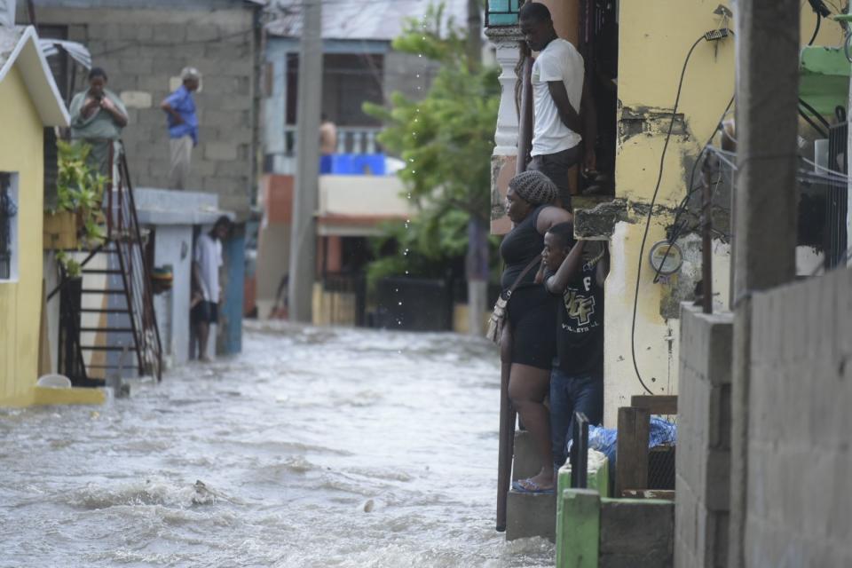 <p>People watch flooded water in a street in Santiago de los Caballeros, Dominican Republic, Sept. 7, 2017. (Photo: Luis Tavarez/EPA-EFE/REX/Shutterstock) </p>