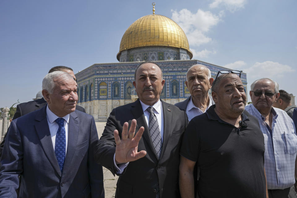 Turkish Foreign Minister Mevlut Cavusoglu, center, and Sheikh Azzam Al-Khatib, left, Director of Jerusalem Waqf Department, with other Palestinian dignitaries visit the Al Aqsa Mosque compound in Jerusalem's Old City, Wednesday, May 25, 2022. (AP Photo/Mahmoud Illean)