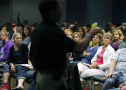 In this Tuesday, Sept. 11, 2018 photo, audience members listen as Des Moines police spokesman Paul Parizek leads a runner's safety talk, in Des Moines, Iowa. The recent killings of female athletes have raised questions about how women can defend themselves and why they must be ready to fight off attackers in the first place. (AP Photo/Charlie Neibergall)