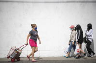 People wear face masks to curb the spread of COVID-19 while walking in Vancouver, British Columbia., Sunday, Aug. 30, 2020. (Darryl Dyck/The Canadian Press via AP)
