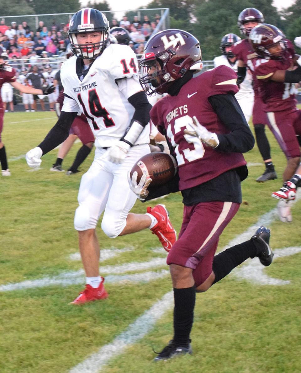Licking Heights' Jamaal Foster attempts to turn upfield with a Bellefontaine defender in pursuit on Friday.