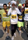 World's oldest marathon runner 94 year old Fauja Singh (C) runs at the start of the short version of 6 kilometers International Marathon in Lahore, 30 January 2005. Singh who was born in Indian Punjab and now resides in London, has the unique distinction of taking part in record six full marathons in London, besides competing in similar events in other parts of the world. AFP PHOTO/Arif ALI