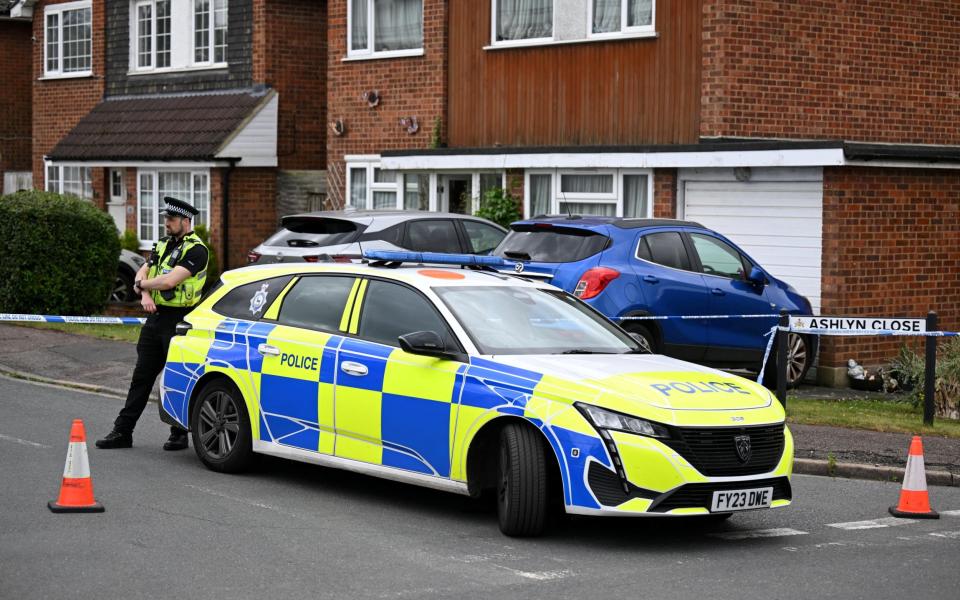 A police cordon is in place at the scene of a triple murder in Ashlyn Close