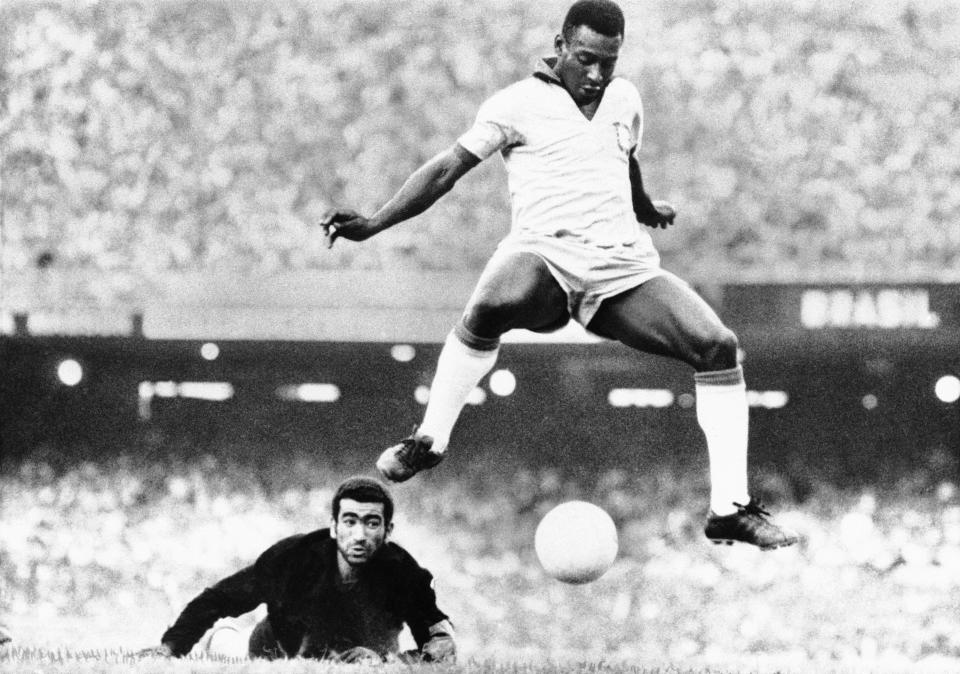 FILE - In this Aug. 1969 file photo, Brazil's Pele scores past Venezuela's goal keeper Fabrizio Fasano in Rio de Janeiro, Brazil. On Oct. 23, 2020, the three-time World Cup winner Pelé turns 80 without a proper celebration amid the COVID-19 pandemic as he quarantines in his mansion in the beachfront city of Guarujá, where he has lived since the start of the pandemic. (AP Photo, File)