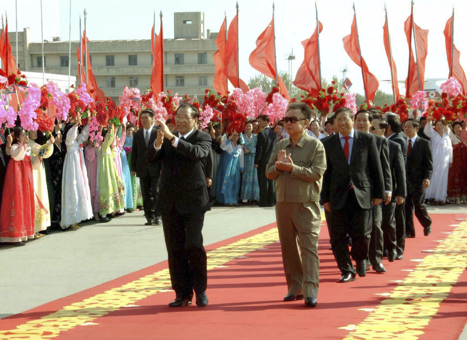 FILE - In this Oct. 16, 2007, file photo released by the North Korean government, Vietnam's Communist Party chief Nong Duc Manh, front left, is welcomed by North Korean leader Kim Jong Il, front right, and citizens with flowers upon arrival in Pyongyang, North Korea. "Vietnam and North Korea have long had fraternal communist ties, so North Korea is familiar with the country and its officials," according to Murray Hiebert, senior associate of the Southeast Asia Program at the Center for Strategic and International Studies in Washington. (Korean Central News Agency/Korea News Service via AP, File)