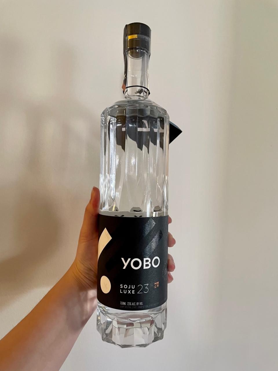 Writer holding a bottle of Yobo Soju Luxe