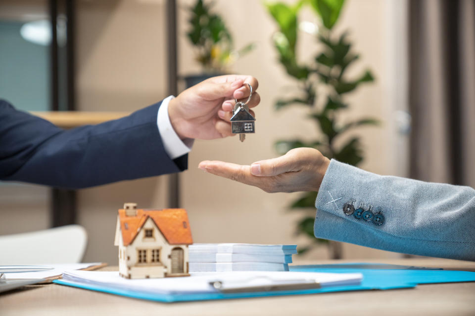 A realtor handing a person some keys