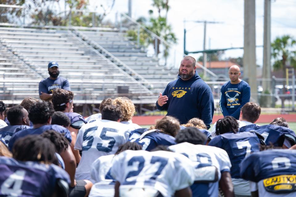 Naples head coach Rick Martin speaks to the team after their first practice since Hurricane Ian brought devastating winds and storm surge to their community.