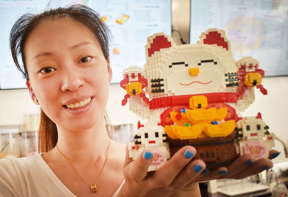 Emily Chen, wife of owner Dominic Chen, poses with one of the many Lego sets she built that are currently on display at Mr. Chen, 210 Rhode Island Ave., Fall River.