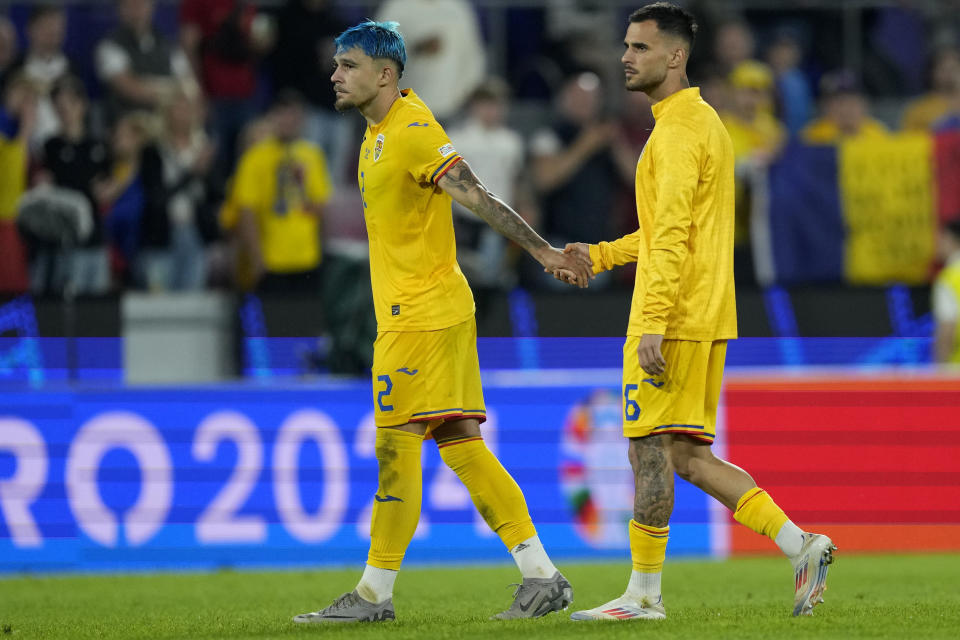 Romania's Andrei Ratiu, left, and Romania's Marius Marin react after a Group E match between Belgium and Romania at the Euro 2024 soccer tournament in Cologne, Germany, Saturday, June 22, 2024. (AP Photo/Martin Meissner)