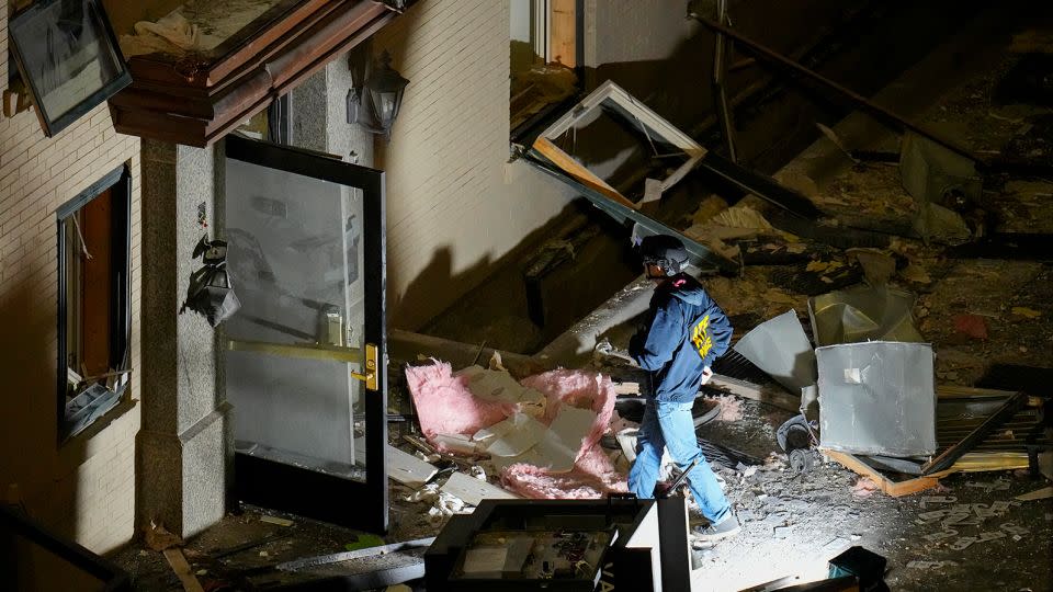 An official surveys an area near the back entrance to the Sandman Signature hotel following an explosion Monday in Fort Worth, Texas. - Julio Cortez/AP