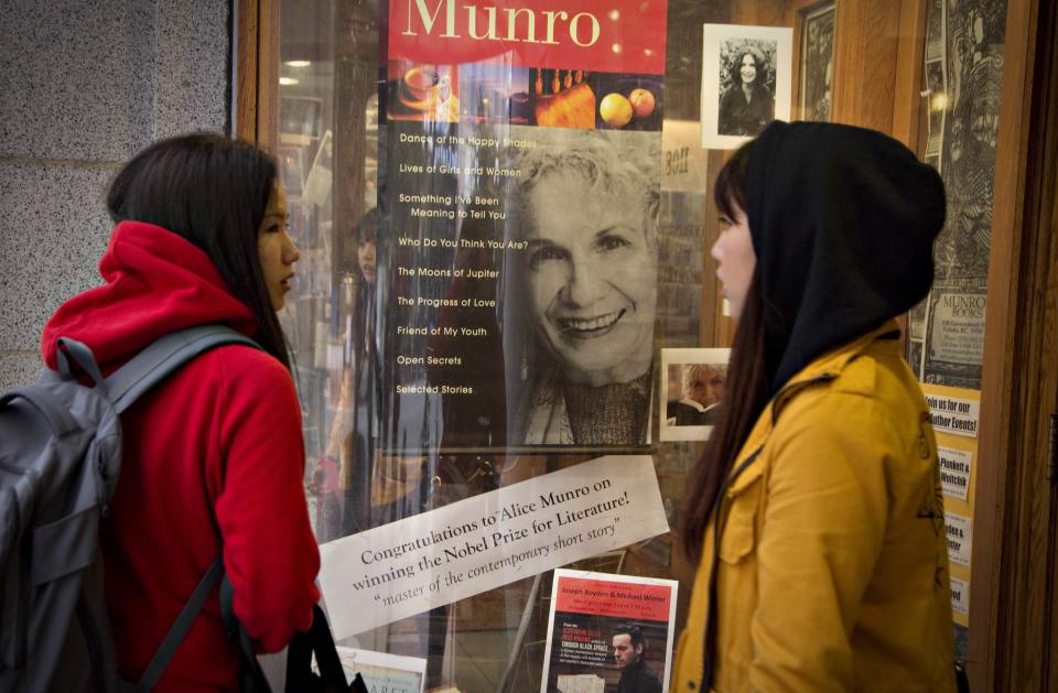 Customers look at a window display congratulating Canadian author Alice Munro at bookstore Munro's Books after she won the Nobel Prize for Literature in Victoria, British Columbia October 10, 2013. Munro won the Nobel Prize on Thursday for her tales of the struggles, loves and tragedies of women in small-town Canada that made her what the award-giving committee called the "master of the contemporary short story." The bookstore, which celebrates its 50th anniversary this year, was opened in 1963 by Jim and Alice Munro at a smaller location nearby. The couple were divorced in 1972, and Jim continues to run the shop. REUTERS/Andy Clark (CANADA - Tags: SOCIETY)