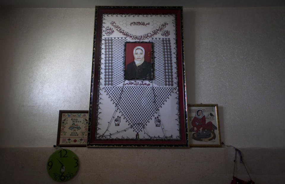 In this photo taken Saturday, Feb. 1, 2014, a photo of late Ayat al-Akhras, who blew herself up in a suicide bombing outside a Jerusalem supermarket in 2002, is seen on a wall at the family house in the West Bank city of Bethlehem. More than a decade later, after appeals from human rights groups, Israel is handing over some 30 bodies of Palestinian assailants, including that of Ayat. (AP Photo/Nasser Nasser)