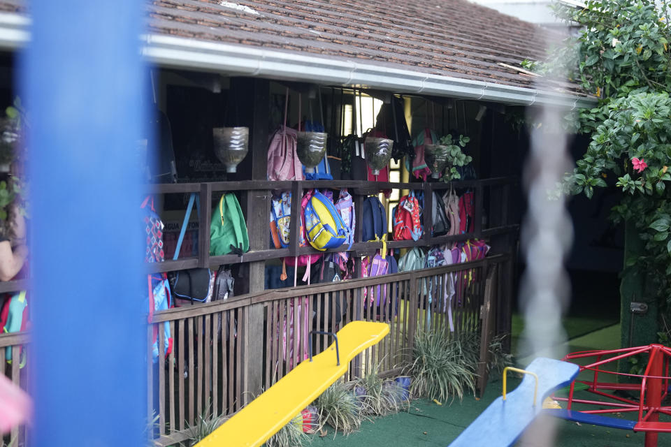 Children's backpack hang on a fence inside the "Cantinho do Bom Pastor" daycare center after a fatal attack on children in Blumenau, Brazil, Wednesday, April 5, 2023. A man with a hatchet jumped over a wall and burst into a day care center Wednesday in Brazil, killing four children authorities said.(AP Photo/Andre Penner)