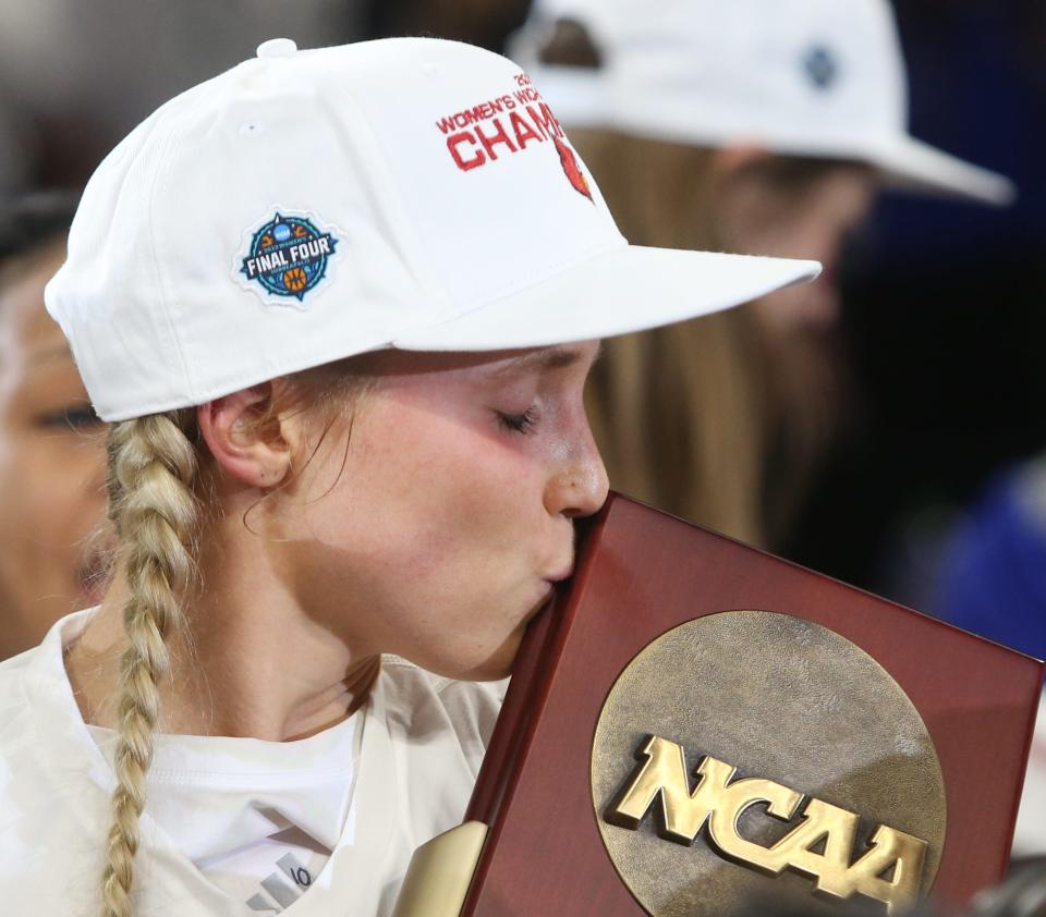 Louisville’s Hailey Van Lith kisses the trophy for advancing to the Final Four.  March 28, 2022