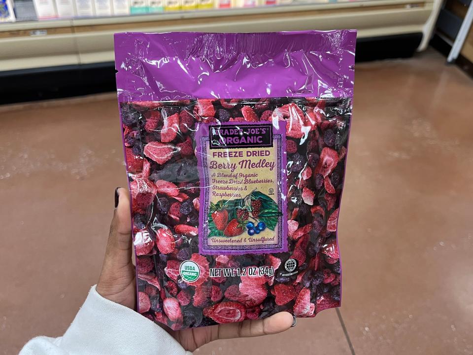 hand holding up a bag of freeze dried berries from trader joes