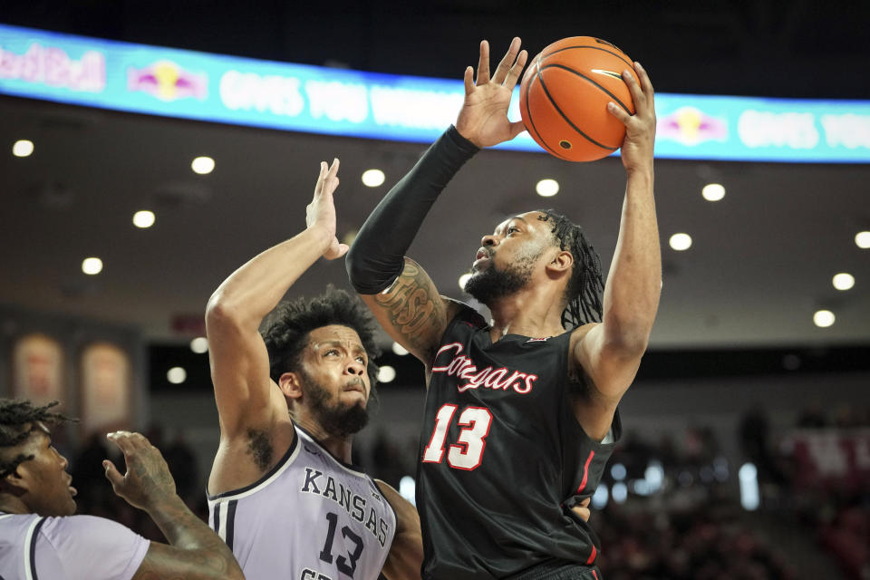 Houston forward J'Wan Roberts (13) drives to the basket as Kansas State forward Will McNair Jr. (13) defends during the first half of an NCAA college basketball game, Saturday, Jan. 27, 2024, in Houston. (Jon Shapley/Houston Chronicle via AP)